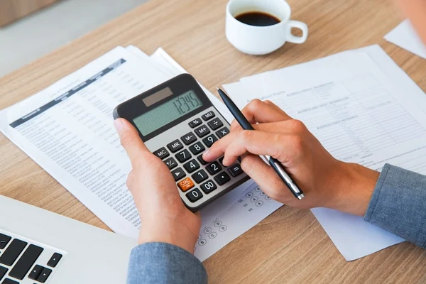 Professional Accountant is accounting BAS report & TAX returns using a calculator.